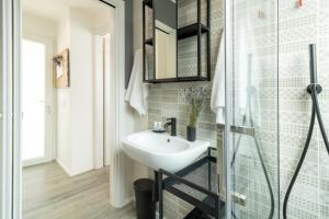 een badkamer met een wastafel en een glazen douche bij Navigli - Chic and Sophisticated Home in Milan in Milaan
