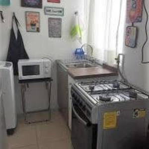 a kitchen with a stove and a microwave at Marina La Serena, Playa Cuatro Esquinas in La Serena