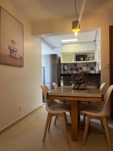 comedor con mesa de madera y sillas en Excelente Apto setor Bueno 1101, en Goiânia