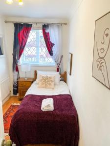 1 dormitorio con cama y ventana en Stunning Modern Cozy 5 star 3 bedroom house-Free Parking Greater London Metro Stations hosted by Tony, en Catford