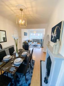 a living room with a table and a fireplace at Stunning Modern Cozy 5 star 3 bedroom house-Free Parking Greater London Metro Stations hosted by Tony in Catford