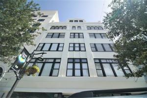 a tall white building with a flag in front of it at The Lofts on Clematis 303 Downtown West Palm Beach in West Palm Beach