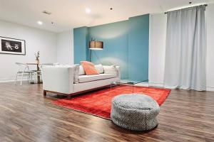 a living room with a white couch and a red rug at The Lofts on Clematis 304 Downtown West Palm Beach in West Palm Beach