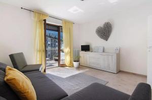 a living room with a couch and a tv at Mary House in Sondrio