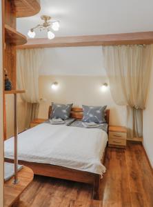 1 dormitorio con 1 cama, suelo de madera y techo en Фенікс, en Yaremche