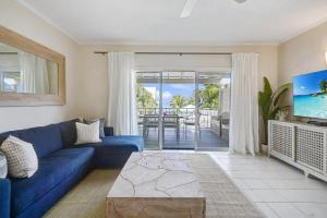 喬治城的住宿－Coconut Bay Villas #116，客厅配有蓝色的沙发和电视