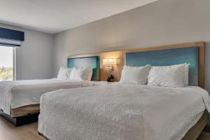 a hotel room with two beds with white pillows at Holiday Inn Express & Suites Destin - Miramar Beach by IHG in Destin +58 photos