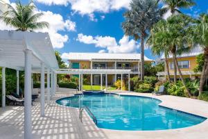 uma piscina em frente a uma casa com palmeiras em Coconut Bay Villas #116 em George Town