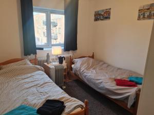 een slaapkamer met 2 bedden en een raam bij Private room in to roomsapartment (Grunneløkka) in Oslo