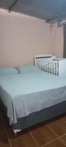 uma cama branca numa sala com em Casa Localizado no Centro de Guape MG em Guapé