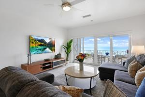 uma sala de estar com um sofá e uma televisão em Coconut Bay Villas #122 em George Town