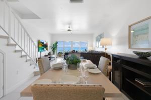 comedor y sala de estar con mesa y sillas en Coconut Bay Villas #122, en George Town