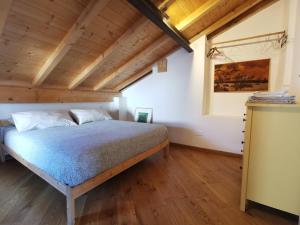 1 dormitorio con 1 cama en una habitación con techos de madera en Appartamento Roma, en Gaggiano