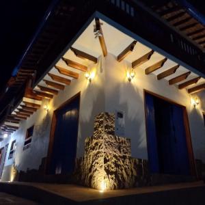 a house with a stone wall and lights on it at Casa Iris Hotel Boutique in Barichara