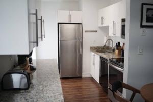 a kitchen with a stainless steel refrigerator and wooden floors at The Lofts on Clematis 309 Downtown West Palm Beach in West Palm Beach