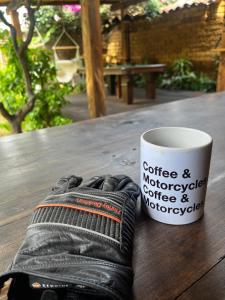 una taza de café y un par de zapatos en una mesa en The Coffee Bean Hostel en San Cristóbal de Las Casas