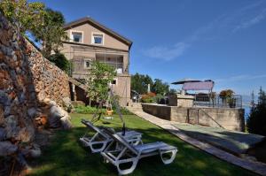 une cour avec une balançoire et une maison dans l'établissement Apartments Viktoria, à Lovran