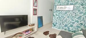 sala de estar con TV de pantalla plana en la pared en Flat com serviço completo e vista Cristo, en Río de Janeiro