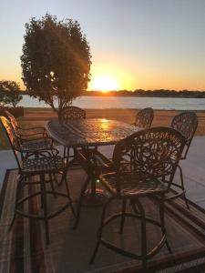 una mesa y sillas con la puesta de sol en el fondo en Lakefront Family Vacation Home close to Frisco and Dallas, en Little Elm