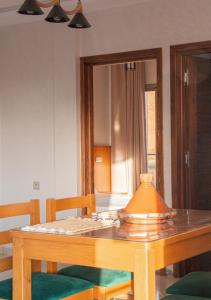 a wooden table with two chairs and a mirror at Malak House in Imsouane