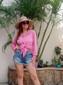 曼塔的住宿－HOSTAL SAN MARINO，穿着粉色衬衫和帽子的女人