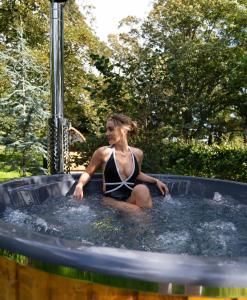 uma mulher sentada num jacuzzi numa piscina em Gileston Manor Luxury B&B em Barry