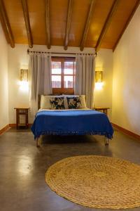 1 dormitorio con cama con sábanas azules y ventana en Casa Agripina- Pariri Quadrado, en Trancoso