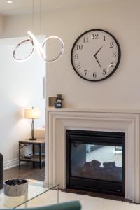 a clock on a wall above a fireplace at Luxury 6 Bedroom - 4 Bathroom Detached Retreat Brampton / Mississauga Border in Brampton