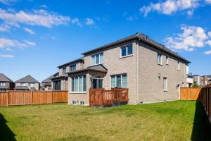 ein Backsteinhaus mit einem Zaun im Hof in der Unterkunft Luxury 6 Bedroom - 4 Bathroom Detached Retreat Brampton / Mississauga Border in Brampton