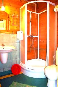 a bathroom with a shower and a toilet and a sink at Tropicana Ϫϫ Holiday Houses in Jastrzębia Góra