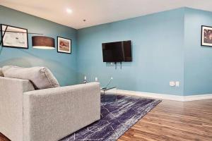 a living room with a couch and a tv on a blue wall at The Lofts on Clematis 503 Downtown West Palm Beach in West Palm Beach