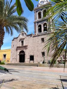 an old brick building with a clock tower at Casas centro Loreto in Loreto