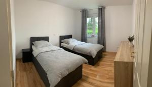 two beds in a room with a wooden floor at Ferienwohnung für 4 Personen in bester Lage ca. 15 km von Bremen City in Achim