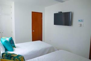 Schlafzimmer mit einem Bett und einem TV an der Wand in der Unterkunft Magico Apartamento Frente al Mar 3 Habitaciones C11A in Coveñas