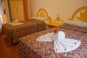 Habitación de hotel con 2 camas y toallas. en Bungalows As De Oros en Rincon de Guayabitos
