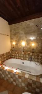 bañera en una habitación con pared de piedra en GIRASOLE Wellness e Relax, en Fossano