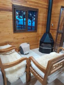 a room with two wooden chairs and a stove at casa dos sonhos in Bom Jardim da Serra