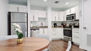 a kitchen with a table with a vase of flowers on it at The Lofts on Clematis 508 Downtown West Palm Beach in West Palm Beach