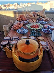 stół z jedzeniem i garnek na górze w obiekcie Fleur de cactus, Guesthouse, Tamraght w mieście Agadir