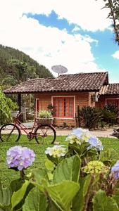 a house with a bike parked in the yard at Pousada das Hortênsias in São Bonifácio