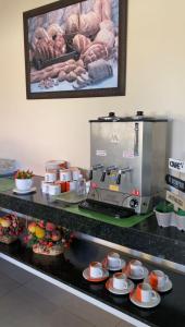 a kitchen with a coffee maker and cups on a counter at Pousada Canaã in São Francisco de Itabapoana