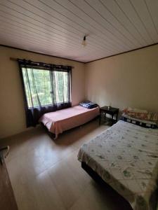 a bedroom with two beds and a window at Descanso imerso à natureza! in Nova Friburgo