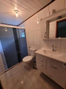 a bathroom with a toilet and a sink and a shower at Descanso imerso à natureza! in Nova Friburgo
