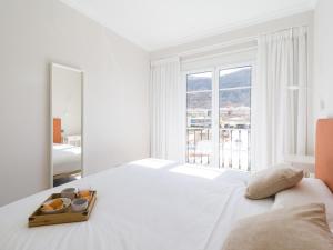 a white bedroom with a white bed and a large window at Amarre Shell in Puerto de Mogán