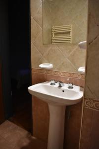 a bathroom with a white sink and a mirror at El Colonial in Colón