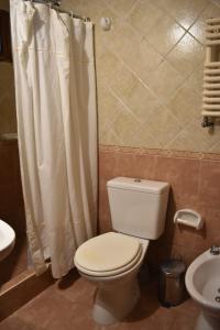 a bathroom with a toilet and a shower curtain at El Colonial in Colón