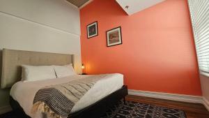una camera da letto con un letto e una parete arancione di The Lofts on Clematis 604 Downtown West Palm Beach a West Palm Beach