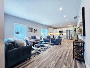 a living room with two couches and a kitchen at Brand New Build Cozy Private 3br2ba Home in South Euclid