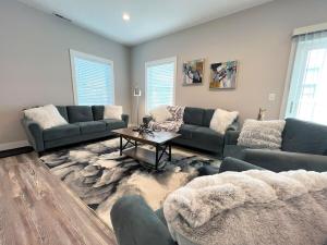 a living room with couches and a table at Brand New Build Cozy Private 3br2ba Home in South Euclid