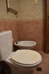 a bathroom with a white toilet and a sink at El Colonial in Colón